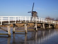 NL, Zuid-Holland, Molenlanden, Kinderdijk 3, Saxifraga-Roel Meijer  Wooden bridge in Unesco World Heritage Site Kinderdijk, South Holland, Netherlands : icy, winter, wintertime, blue sky, reed, unesco world heritage site, Kinderdijk, South Holland, Holland, Netherlands, windmill, wooden, bridge, historic, building, monument, travel destinations. canal, ice